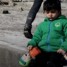 في يد دمية وبالأخرى كيس “تشيبس”.. مشهد مؤلم لطفل سوري وسط الركام